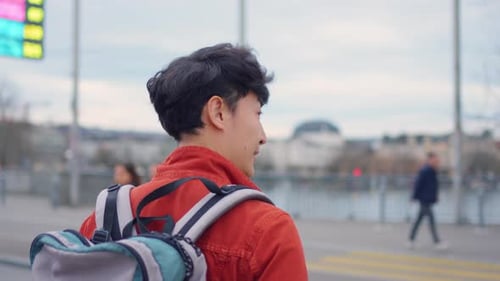Asian attractive man backpacker walking around beautiful road in city.