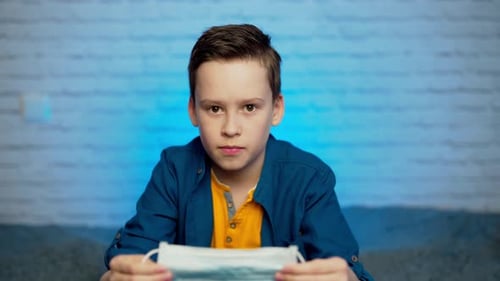 Boy wearing medical face mask. Self isolation. Covid-19 virus epidemic pandemic. Social distancing.