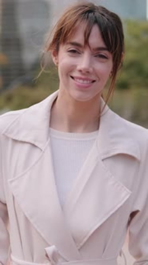 Vertikales Video, Glückliche junge Geschäftsfrau oder hübsche Dame, die im Stadtpark lächelt