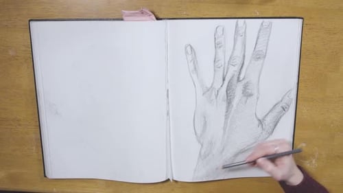 Mujer dibujando el dorso de la mano en el bloc de dibujo