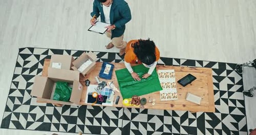 Teamwork, shipping and fashion designer people wrapping a product in office for courier delivery