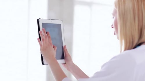 Woman Doctor Using Tablet Examining X-Ray in Hospital