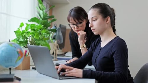 Teen and Adult Working Together on Laptop
