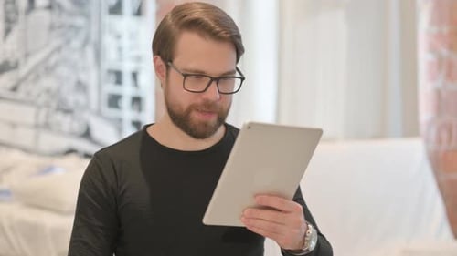 Frustrated Man Using Tablet Indoors