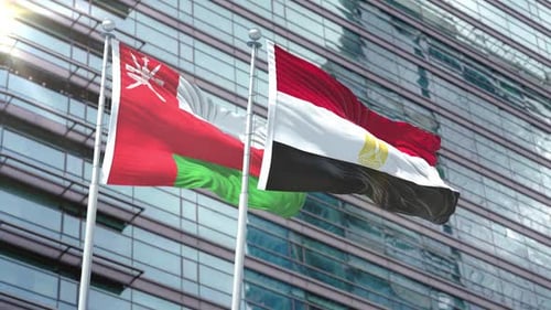 Flags of Oman and Egypt Waving in Front of Modern Corporate Building