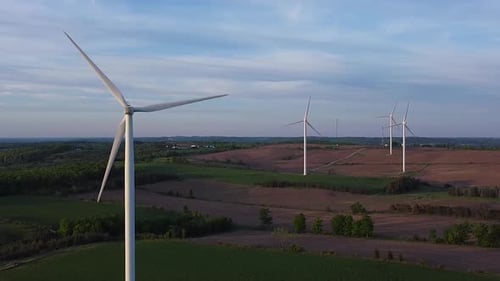 Aerial of clean renewable sustainable energy wind turbine farms on fields; punch in