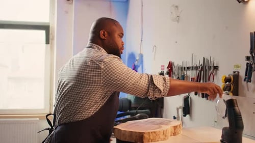 Man Inspecting Wood in Workshop