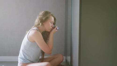 Woman Applying Makeup in Her Room