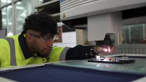 Der Mechaniker arbeitet im Forschungslabor mit elektronisch Leiterplatte und Mikroskop.