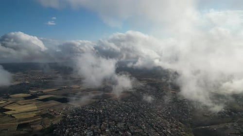 Aerial View of Cityscape Among Clouds and Countryside
