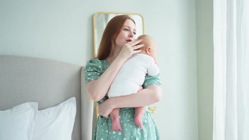 Mother Tenderly Holds Her Newborn Baby Indoors