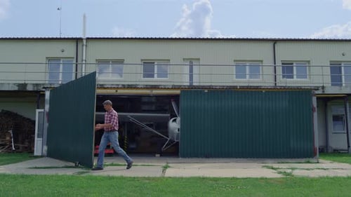 Pilot Opening Gates Hangar Adventure Travel