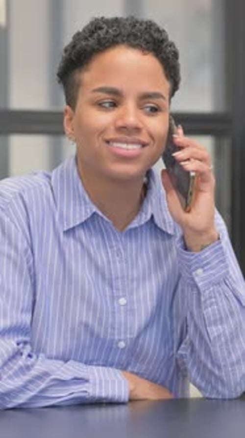 Young Woman Talking On Phone At Indoor Table