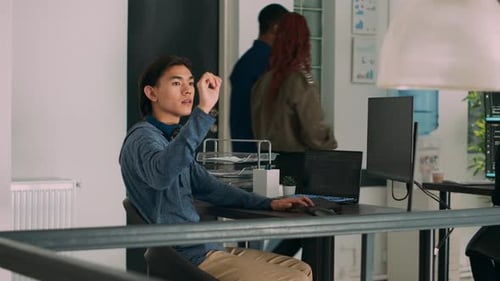 Programador escribiendo el código fuente en la computadora y girando la cabeza para usar el holograma Ar