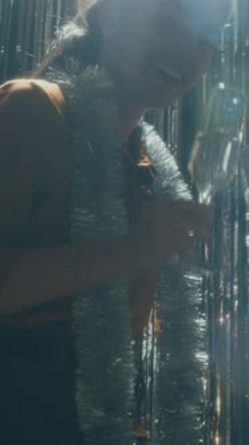 Woman Celebrating with Champagne and Silver Streamers
