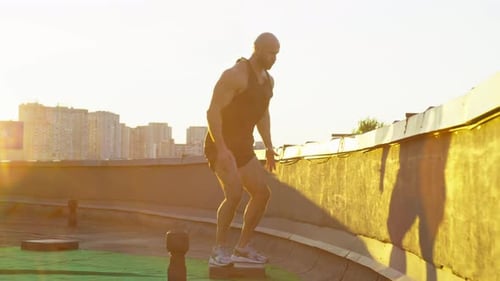 Muscular Man Doing Squats Training in the City at Sunset