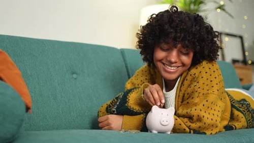 Saving Money Investment for Future African American Girl Putting Money Coin in Pink Piggy Bank