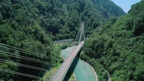 Aerial of a Highway in the Mountains An Automobile Cablestayed Bridge Over a Mountain River in a