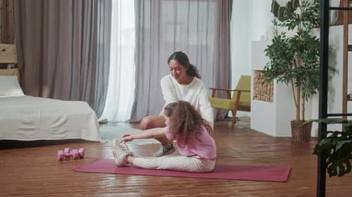 Woman and Girl Stretching Together at Home