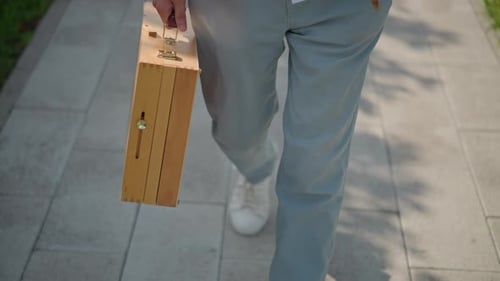 Walking with Vintage Paint Case Casual Street Artist with Stylish Footwear An Artist Casually Walks