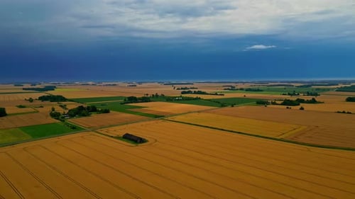 Aerial view of dramatic storm clouds above farmlands and countryside fields