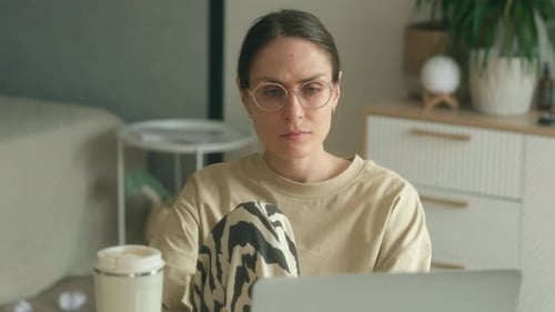 Young Adult Woman Working from Home on Laptop