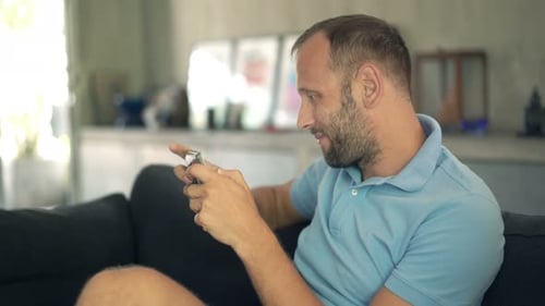 Man using mobile phone on sofa indoors