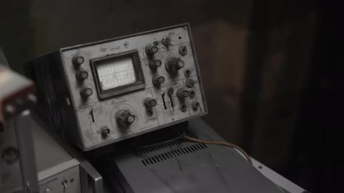 Primer plano de una escena de taller de control de instrumentos vintage que muestra perillas y diales polvorientos con etiquetas desgastadas