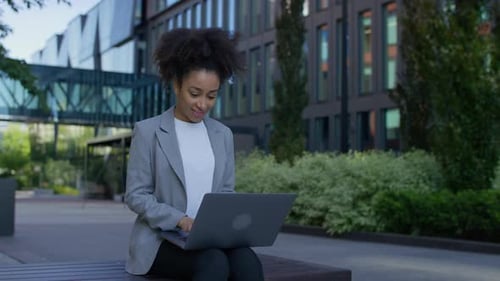 Jeune professionnel travaillant à distance sur un ordinateur portable à l'extérieur