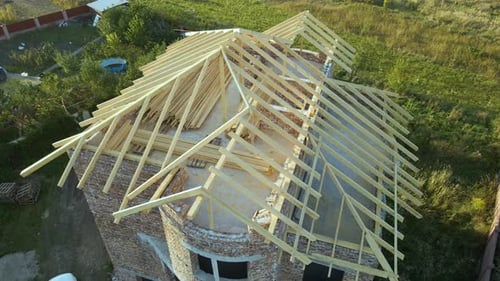 Aerial View of Unfinished Residential House with Wooden Roof Frame Structure Under Construction