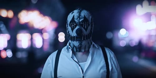 Masked Individual in Scary Clown Mask at Night