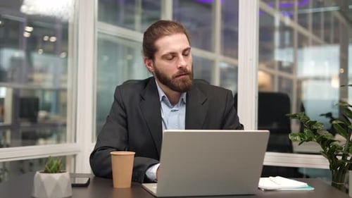 Focused Office Manager Using Modern Laptop for Work at Comfortable Workplace