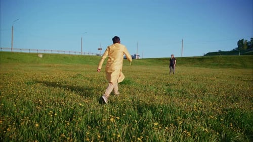 Two Men Playing and Running in a Field of Yellow Flowers