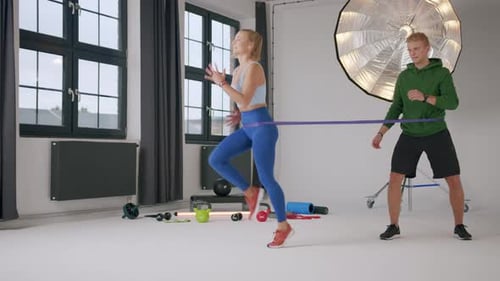 Athletic Woman Resistance Band Training with Trainer