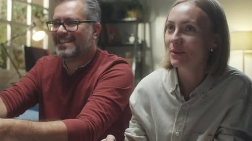 Smiling Couple Playing Video Games at Home