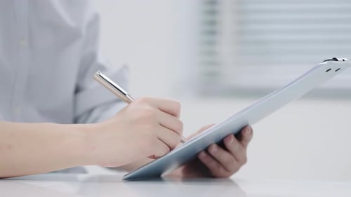 Medizinischer männlicher Arbeiter, professioneller Arzt, der die Zwischenablage in der Hand hält und das Formular für den medizinischen Bericht ausfüllt