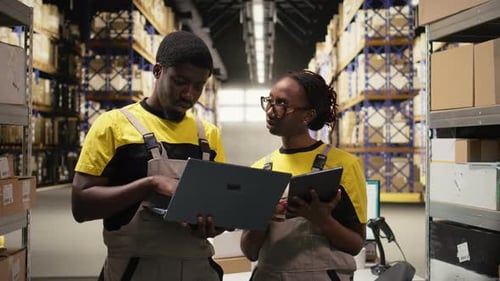 Black Coworkers Preparing Orders in Boxes for Shipment in Large Warehouse