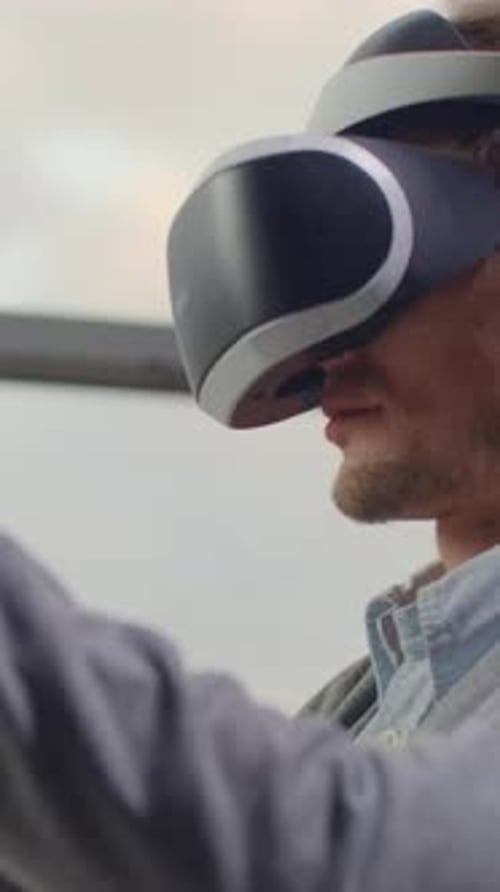 Mann mit Headset interagiert mit virtueller Umgebung im Freien, fokussierte und engagierte Seitenansicht
