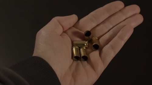 9-mm-Kugelpatronenhülsen lassen sich von Hand öffnen und zum Vorschein bringen. Hand wieder schließen, nachdem abgefeuerte Kugeln gezeigt wurden
und