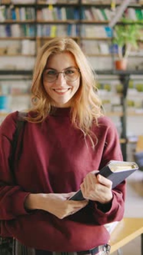 Uma estudante ruiva sorridente de óculos usando uma saia xadrez de líder de torcida segura uma mochila e livros