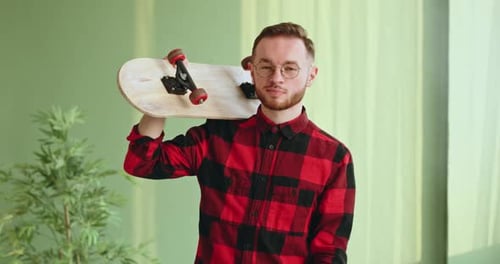 Man with Skateboard Over Shoulder Indoors