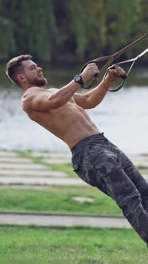 Man doing exercise outdoors. Fit young man exercising in park