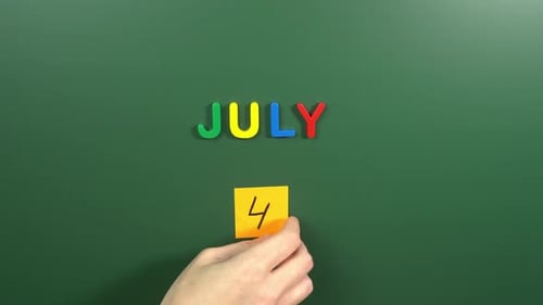 Hand sticking a sticker 4 July calendar day on school board. 4 date of July. Fourth day July