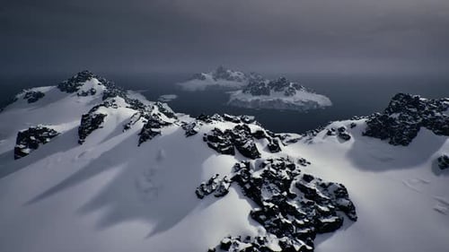 Frozen Ridge with Rugged Peaks Under Stormy Sky Evoking Adventure