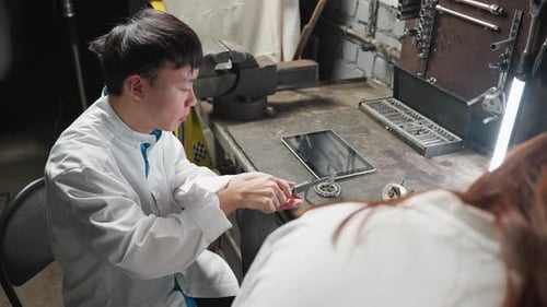 Technician Using Tablet in Lit Automotive Workshop