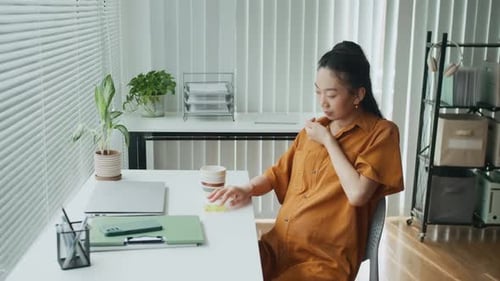 Caring Expectant Mother Taking Vitamin in Capsule at Office Desk