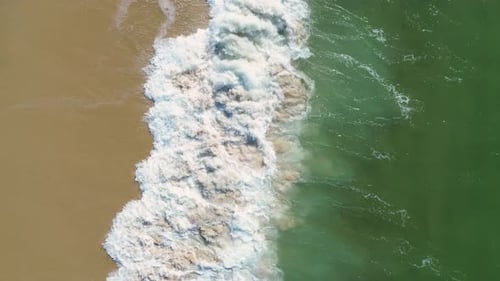 Vidéo aérienne par drone des vagues de l'océan Atlantique se jetant sur une plage de sable, belle vue de dessus de
