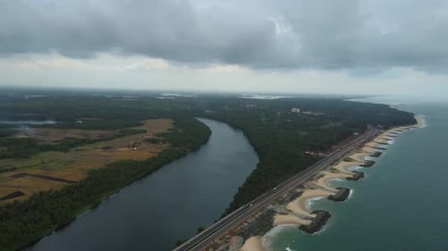Aerial drone shot of Maravanthe Beach, showcasing the parallel highway and the Souparnika River.