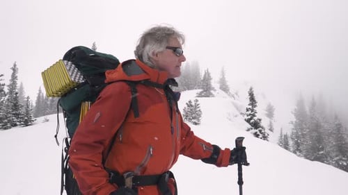Man Hiking with Backpack in Snowy Mountain Wilderness