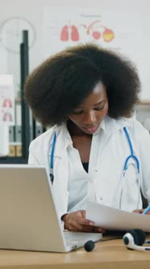 Close Up of Pretty Smart African American Woman Medical Worker in White Coat with Stethoscope Which